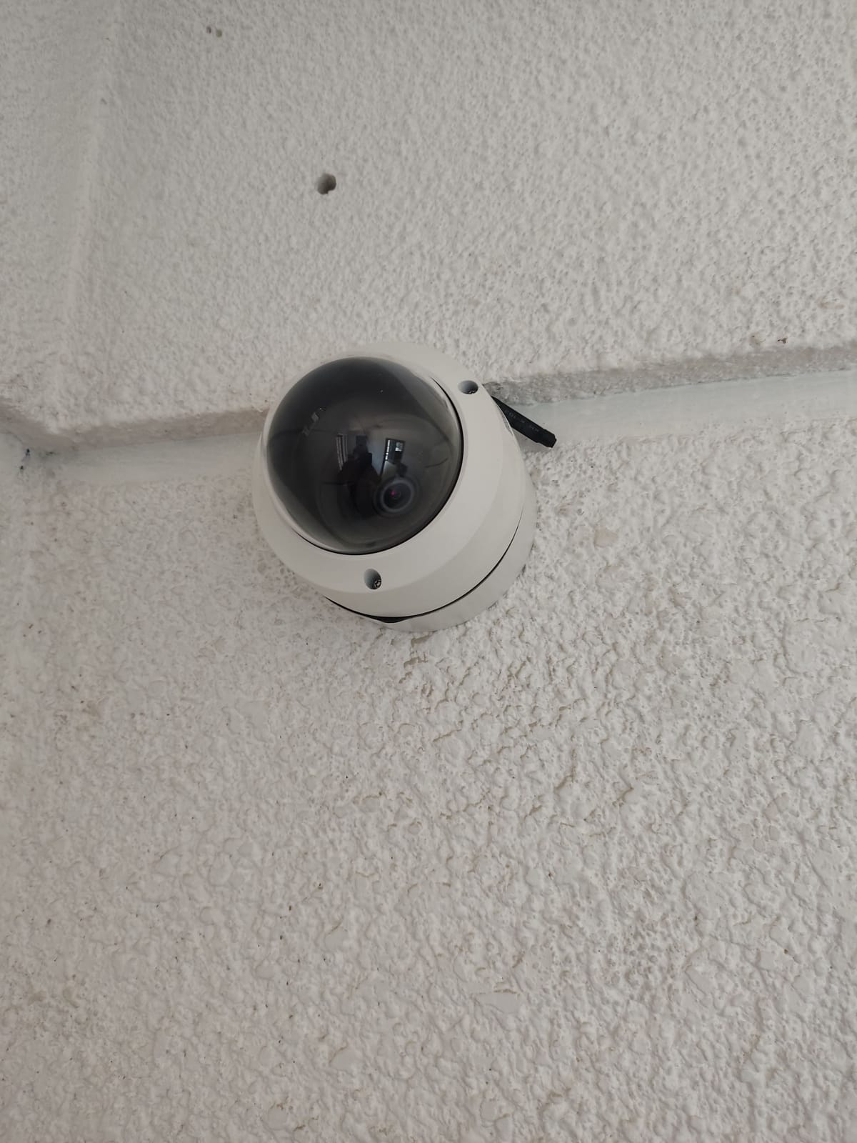 Mini PTZ Hikvision en pared blanca con canaleta recta y cableado oculto