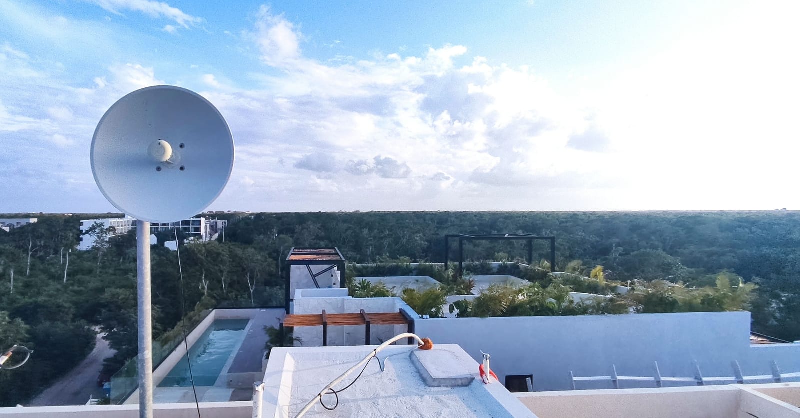 Antena tipo plato para enlace punto a punto montada en un mástil sobre azotea