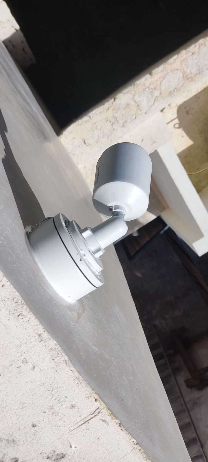 Cámara bala Hikvision montada sobre una base circular en el borde de un muro exterior