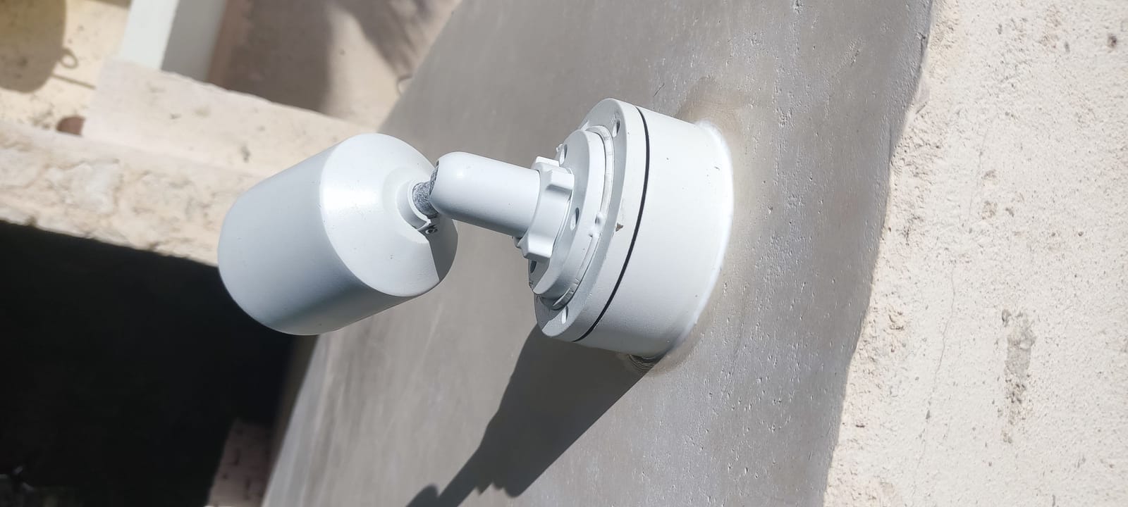 Cámara bala blanca Hikvision fijada a un muro con base de montaje limpia